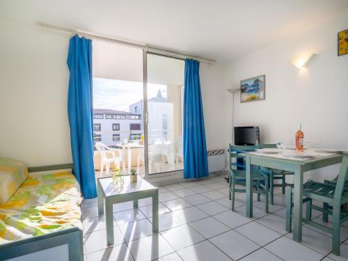 a living room with a bed and a table and chairs at Apartment La Palme d'Or-5 by Interhome in Cap d'Agde