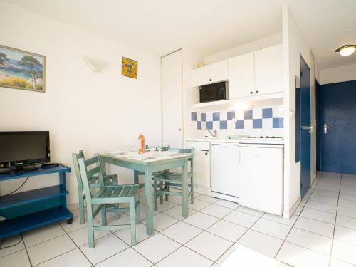 une cuisine avec une table et des chaises dans une pièce dans l'établissement Apartment La Palme d'Or-5 by Interhome, au Cap d'Agde