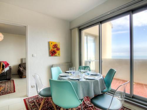 a dining room with a table and chairs and a window at Apartment De La Plage-3 by Interhome in Cap d'Agde