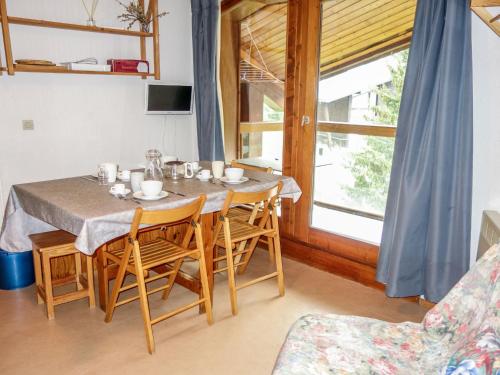 a dining room with a table and chairs and a window at Apartment Pierres Blanches F et H by Interhome in Le Cugnon