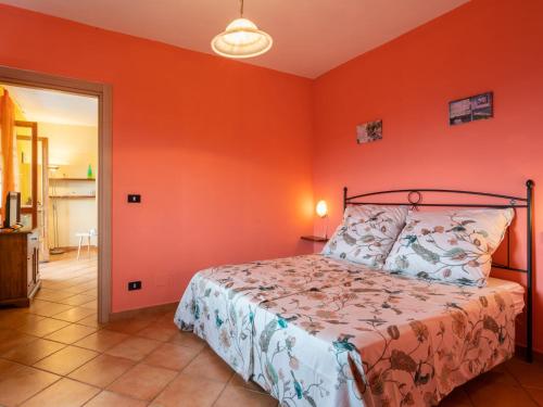 a bedroom with orange walls and a bed in a room at Apartment Mimosa - VLO200 by Interhome in Lecchiore