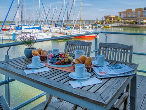 a picnic table with a plate of food on a marina at Holiday Home Hafenhaus by Interhome in Großpösna