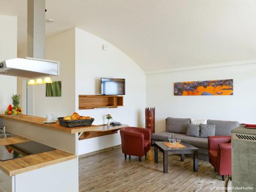 a kitchen and living room with a couch and a table at Holiday Home Dünenhaus Comfort by Interhome in Großpösna