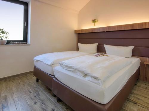 a bedroom with two beds with white sheets at Holiday Home Dünenhaus Comfort by Interhome in Großpösna