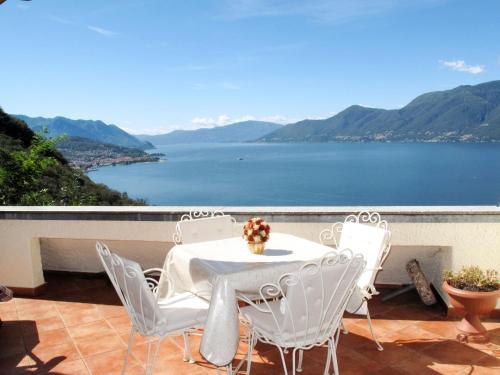 Maccagno InferioreにあるApartment Il Gaggio by Interhomeのテーブルと椅子、水辺の景色を望むバルコニー
