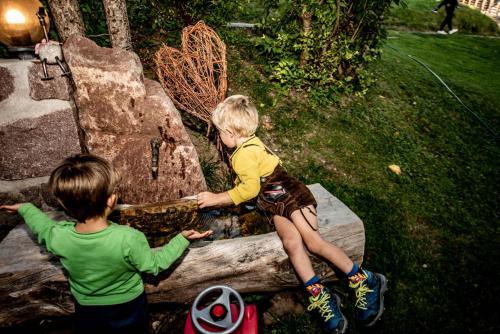 two young children playing on a log in a playground at Haus Lohengrin Ferienwohnung 4 in Siusi