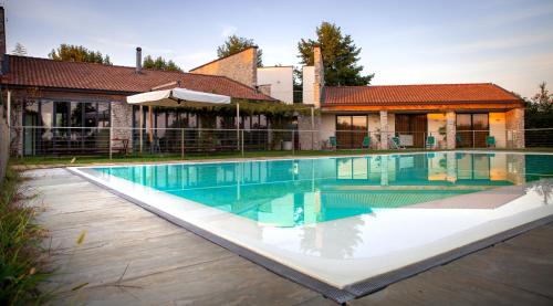 Marmirolo的住宿－科爾特狂歡節農莊酒店，房屋前的游泳池
