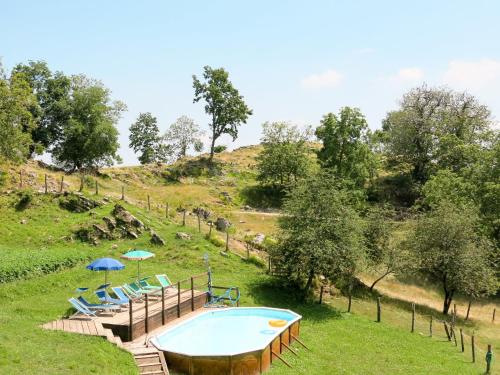 a pool in a field with chairs and umbrellas at Holiday Home Paradiso II by Interhome in Bolognana