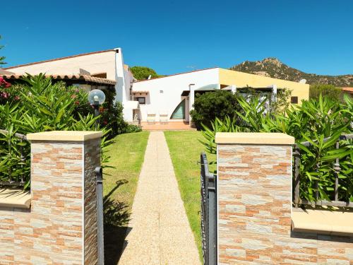 un vialetto che conduce a una casa con cancello di Holiday Home Mirto Marino - REI410 by Interhome a Costa Rei