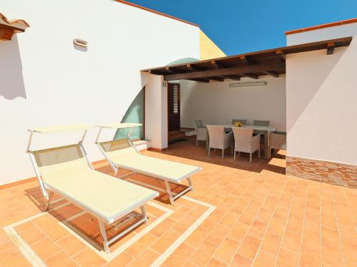 un patio con 2 sedie e un tavolo di Holiday Home Mirto Marino - REI410 by Interhome a Costa Rei