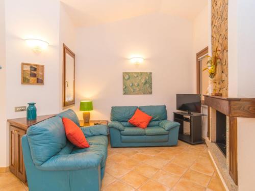 een woonkamer met twee blauwe banken en een open haard bij Holiday Home Rei Sole - REI303 by Interhome in Costa Rei