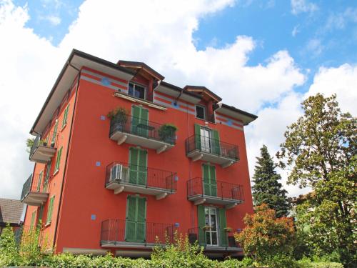 un edificio rojo con ventanas y balcones. en Apartment Franco by Interhome, en Porto Ceresio