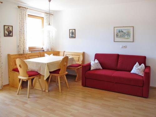 - un salon avec un canapé rouge et une table dans l'établissement Apartment Obermüllerhof-2 by Interhome, à Maranza