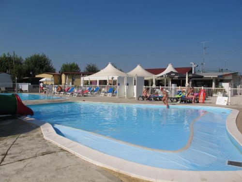 duży, niebieski basen z osobami w tle w obiekcie Holiday Home Camping Butterfly-2 by Interhome w mieście Peschiera del Garda