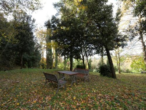 two benches and a picnic table in a park at Holiday Home Il Pozzo by Interhome in Podere Caminino