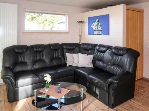 um sofá de couro preto numa sala de estar com uma mesa em Holiday Home Erzeberg-4 by Interhome em Balhorn