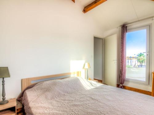 une chambre avec un lit et une grande fenêtre dans l'établissement Apartment Les Andalouses by Interhome, au Cap d'Agde