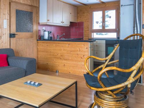 ein Wohnzimmer mit einem Stuhl und einem Tisch sowie eine Küche in der Unterkunft Chalet Chalet de la Vue des Alpes by Interhome in La Vue des Alpes