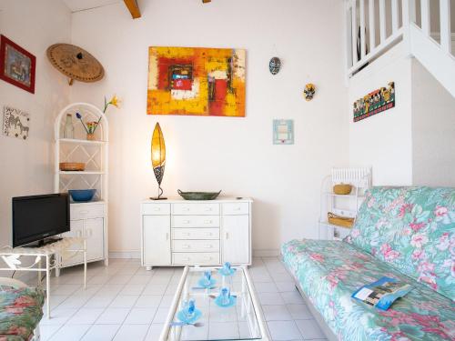 ein Wohnzimmer mit einem Sofa und einem TV in der Unterkunft Holiday Home Les Cristallines-3 by Interhome in Cap d'Agde