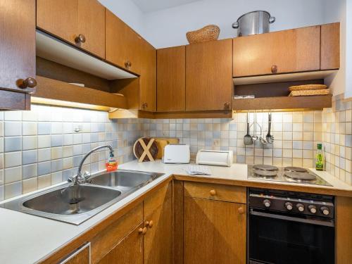 eine Küche mit Holzschränken und einem Waschbecken in der Unterkunft Apartment Plathner by Interhome in Bad Hofgastein