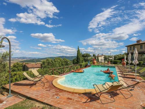 una grande piscina con sedie di Apartment Appartamento Ginepro - Borgo in Chianni by Interhome a Chianni