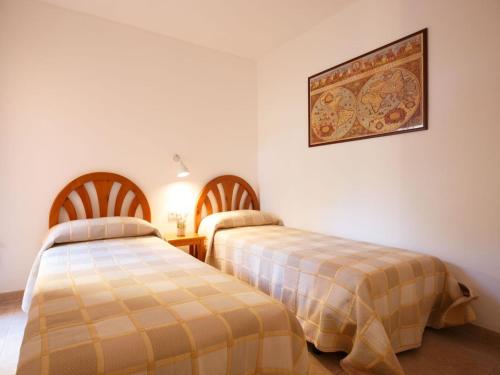 1 dormitorio con 2 camas y una foto en la pared en Apartment Sa Guilla 3 dorm by Interhome, en Begur