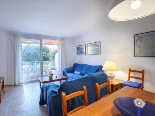 sala de estar con sofá azul y mesa en Apartment Sa Guilla 3 dorm by Interhome, en Begur