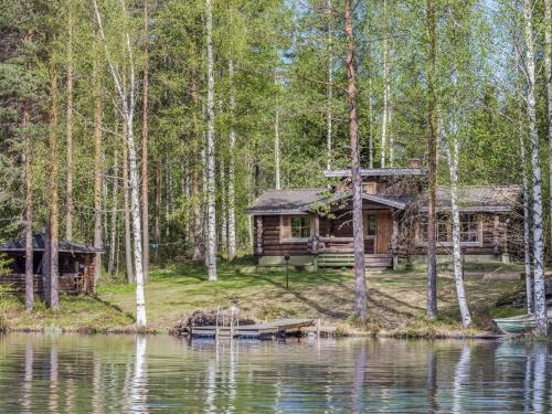 une cabane en rondins dans les bois à côté d'un lac dans l'établissement Holiday Home Papanmökki by Interhome, à Huuhanaho