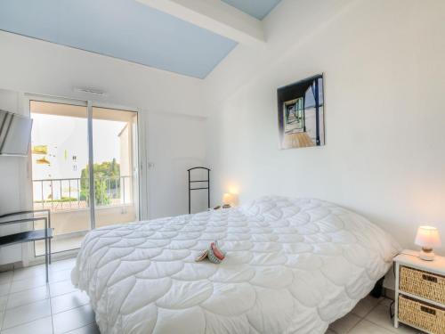 un grand lit blanc dans une chambre avec une fenêtre dans l'établissement Apartment Bella Vista by Interhome, au Cap d'Agde