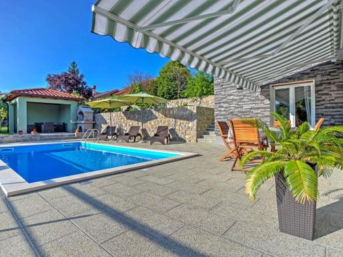 a patio with a swimming pool and an umbrella at Holiday Home Dante by Interhome in Marčelji