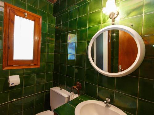 ベグールにあるHoliday Home Calsina Baix by Interhomeの緑のタイル張りのバスルーム(シンク、鏡付)