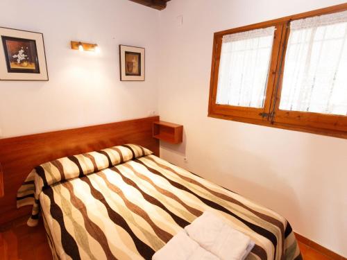 ベグールにあるHoliday Home Calsina Baix by Interhomeのベッドルーム1室(ストライプ掛け布団、窓付)