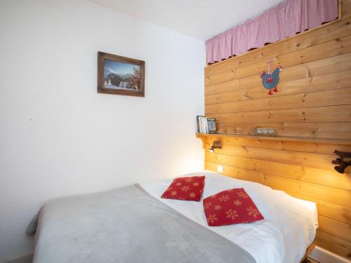 une chambre avec un lit avec deux oreillers rouges dessus dans l'établissement Apartment Le Hameau du Borsat - Val Claret-8 by Interhome, à Tignes