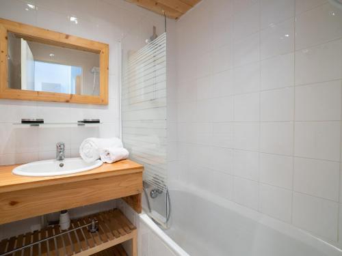 une salle de bain avec un lavabo, une baignoire et un miroir dans l'établissement Apartment Le Hameau du Borsat - Val Claret-8 by Interhome, à Tignes