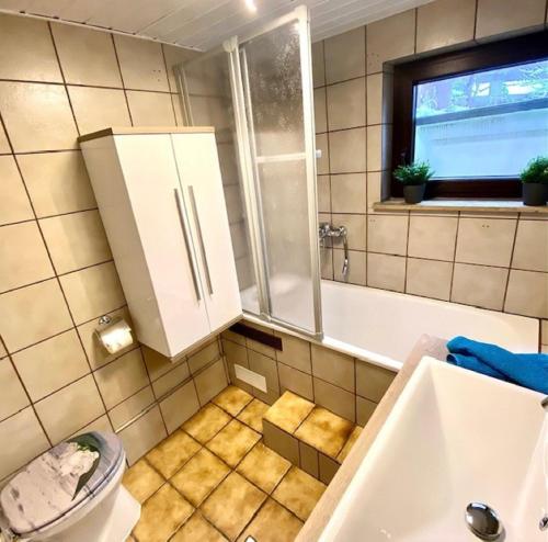 La salle de bains est pourvue d'un lavabo, d'une baignoire et de toilettes. dans l'établissement Ferienwohnung Vogel, à Selbitz