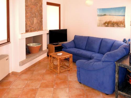 un soggiorno con divano blu e TV di Holiday Home Rei Sole - REI302 by Interhome a Costa Rei