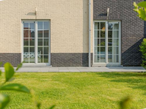 twee deuren op een bakstenen gebouw met een gazon bij Apartment Sea Garden by Interhome in Mispelburg
