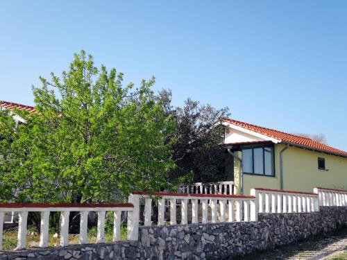 una cerca blanca frente a una casa amarilla en Holiday Home Camp Marko - ROZ335 by Interhome, en Zečevo