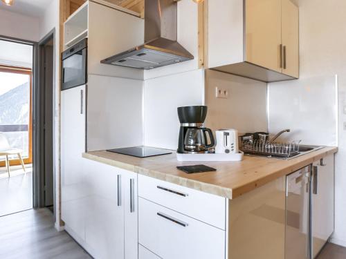 une cuisine avec des armoires blanches et un comptoir dans l'établissement Apartment Lunik Orion-46 by Interhome, au Corbier