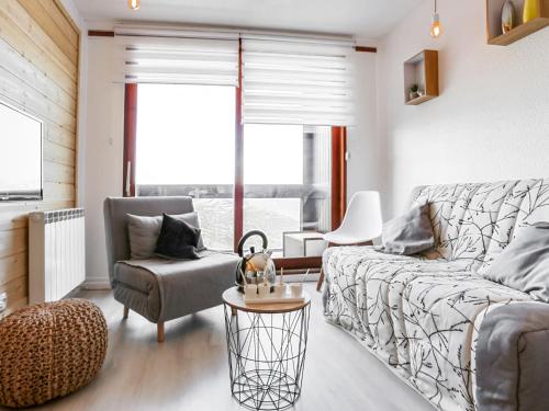 ein Wohnzimmer mit einem Sofa und einem Stuhl in der Unterkunft Apartment Lunik Orion-46 by Interhome in Le Corbier