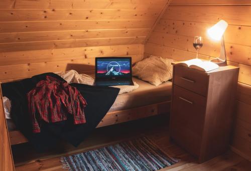 a bedroom with a bed with a laptop on it at Leśna 21 Dom Południe przy PUSZCZA BIAŁOWIESKA in Łuka