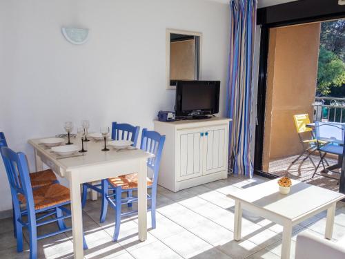 une salle à manger avec une table, des chaises et une télévision dans l'établissement Apartment La Marina by Interhome, à Bandol