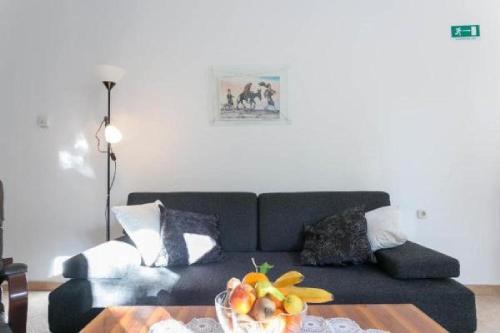 a living room with a couch and a table with a bowl of fruit at Apartment Anita in Dubrovnik