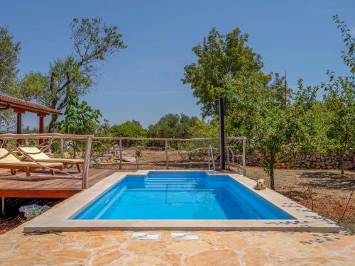 a swimming pool in a yard with a wooden deck at Holiday Home Marijo by Interhome in Stari Grad