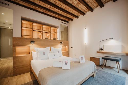 a bedroom with a large bed with two price signs on it at Petit Luxe St. Pere in Terrassa