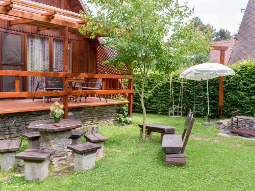 un patio trasero con una mesa de picnic y una sombrilla en Chalet Dehtáře by Interhome, en Hluboká nad Vltavou