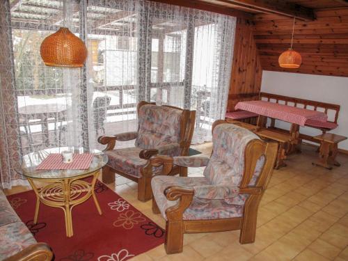 a living room with chairs and a table and windows at Chalet Dehtáře by Interhome in Hluboká nad Vltavou