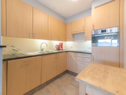 cocina con armarios de madera y encimera en Apartment Seaside by Interhome, en Bredene