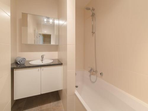 y baño blanco con lavabo y ducha. en Apartment Seaside by Interhome, en Bredene