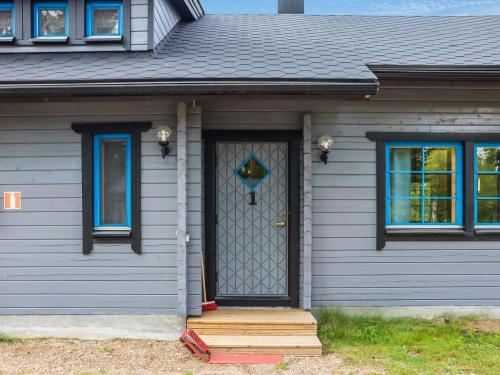 ein graues Haus mit einer Tür und einer Veranda in der Unterkunft Holiday Home Villa tassu 1 by Interhome in Kotila